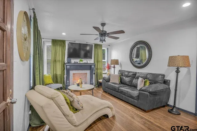 a living room with fireplace furniture and a large window
