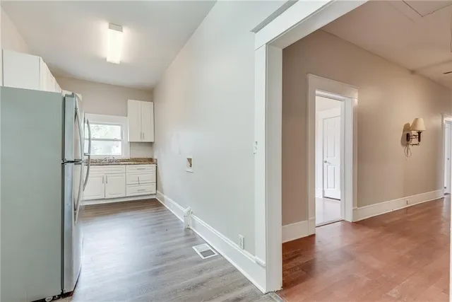 a view of empty room with wooden floor and electronic appliances
