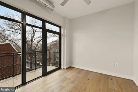 a view of an empty room with wooden floor and iron stairs