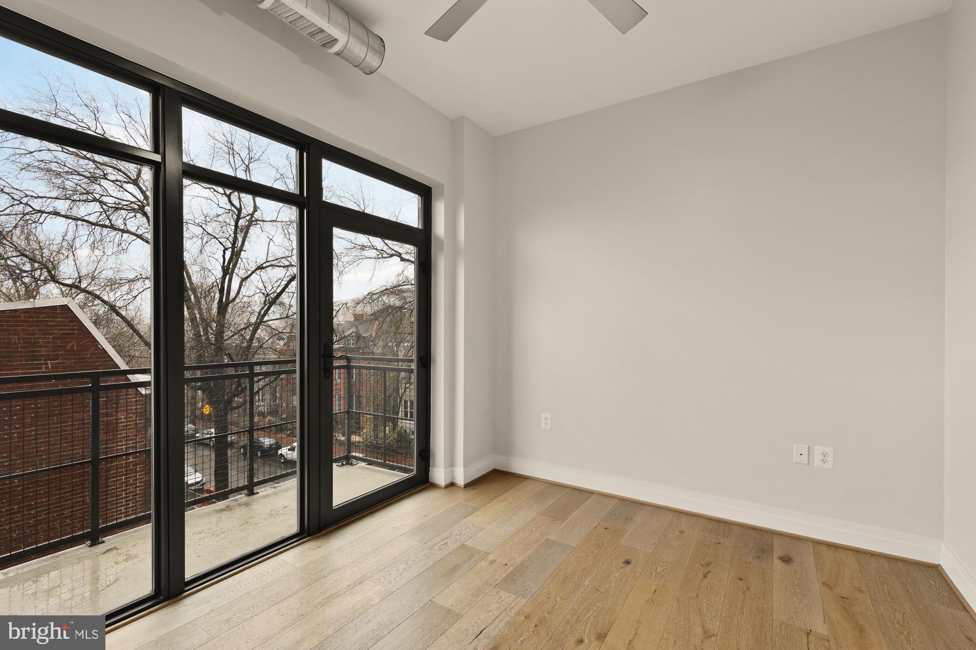 301 H Street Northeast, Unit 305 Washington, DC 20002 - Photo 14 of 25 a view of an empty room with wooden floor and iron stairs