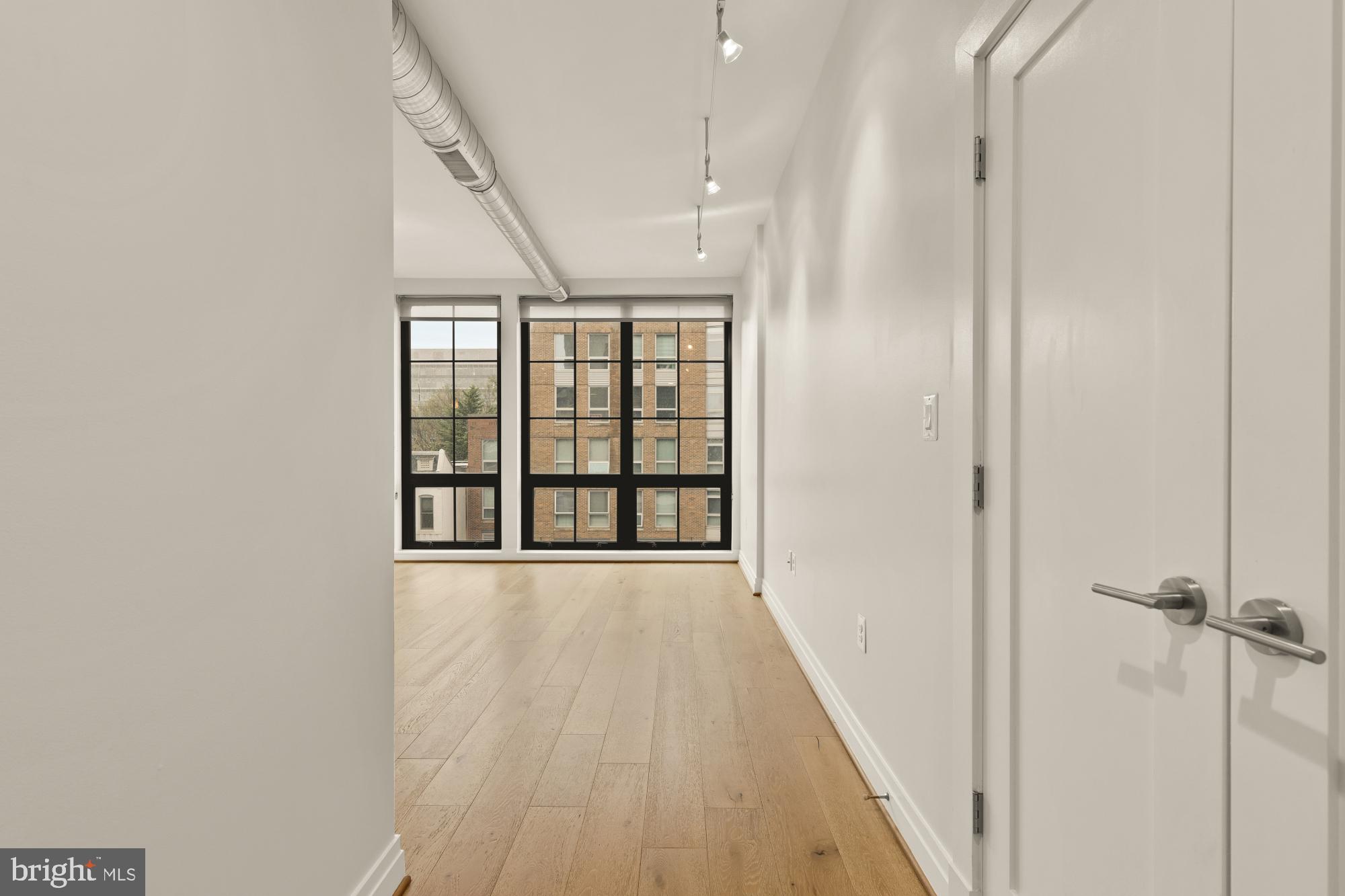 301 H Street Northeast, Unit 305 Washington, DC 20002 - Photo 2 of 25 a view of an empty room with wooden floor and a window