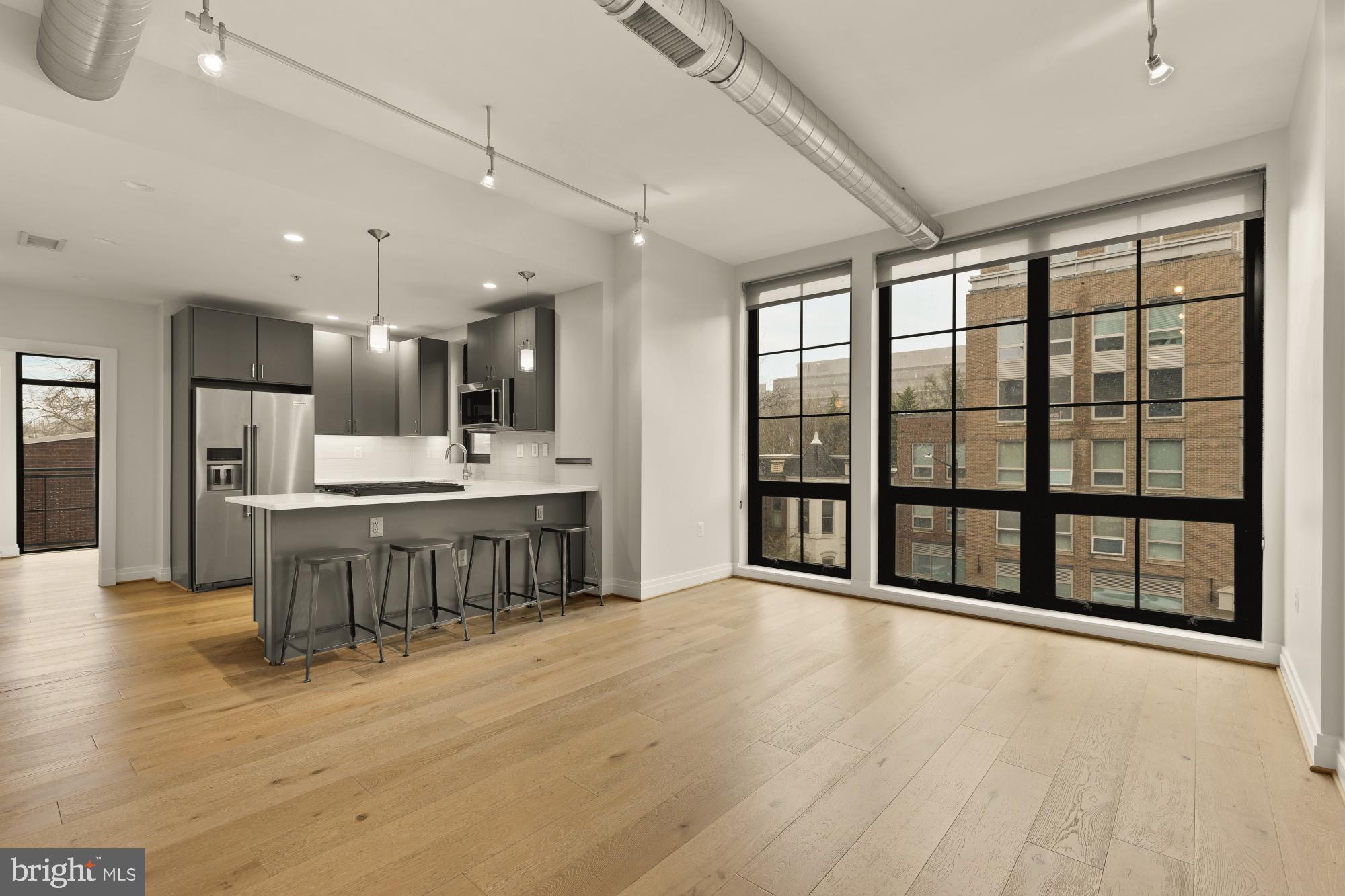 301 H Street Northeast, Unit 305 Washington, DC 20002 - Photo 4 of 25 a large kitchen with a large window and stainless steel appliances