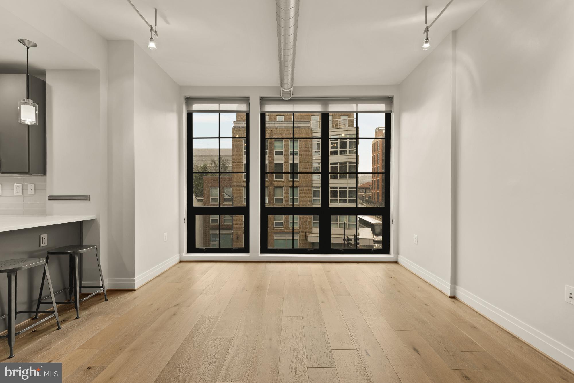 301 H Street Northeast, Unit 305 Washington, DC 20002 - Photo 5 of 25 a view of an empty room with wooden floor and a window