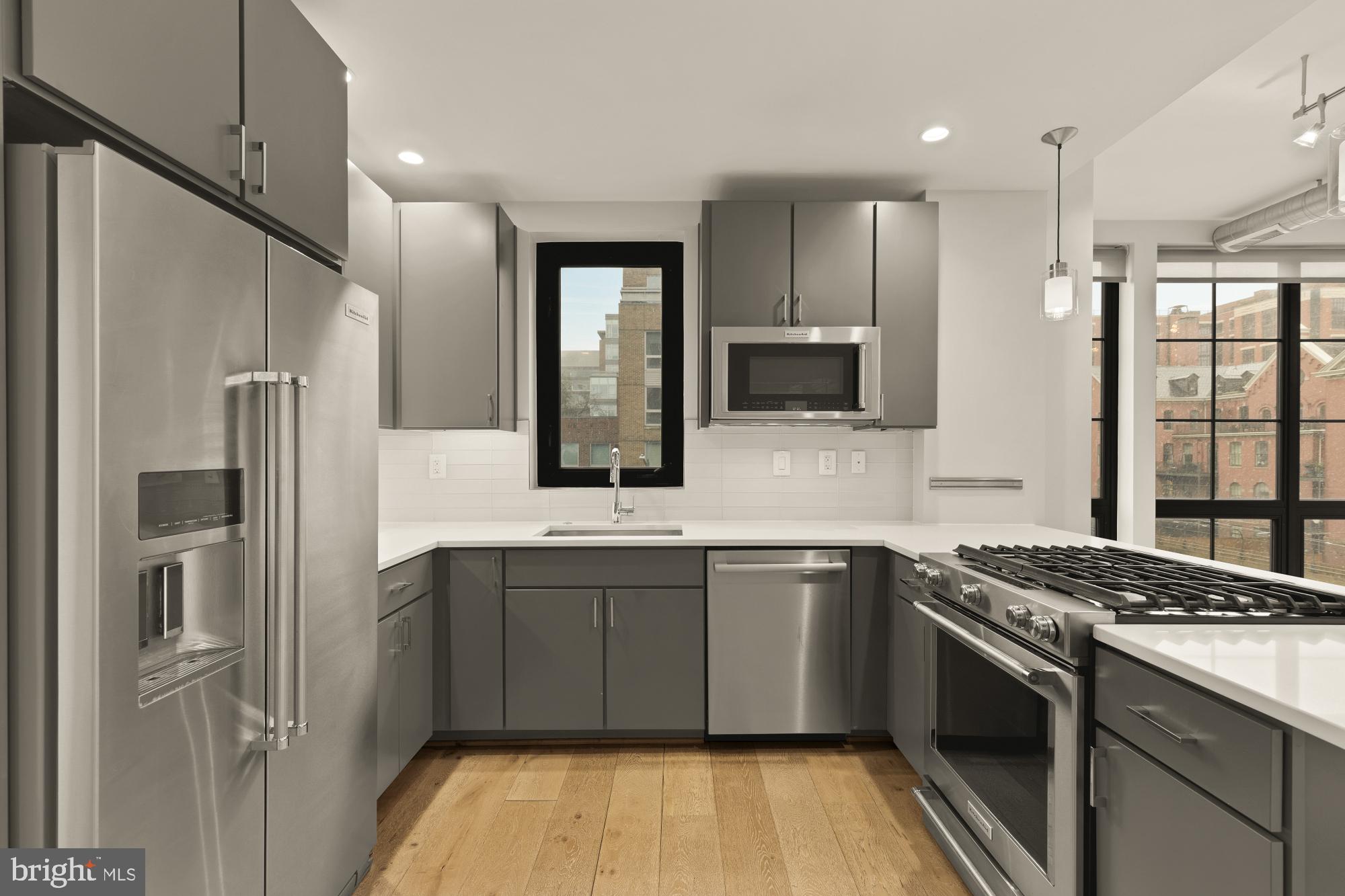 301 H Street Northeast, Unit 305 Washington, DC 20002 - Photo 10 of 25 a kitchen with stainless steel appliances granite countertop a sink stove and refrigerator