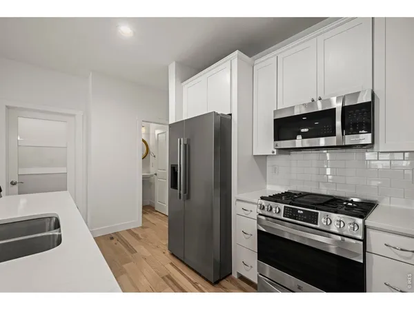 a kitchen with stainless steel appliances a refrigerator a stove a microwave and cabinets