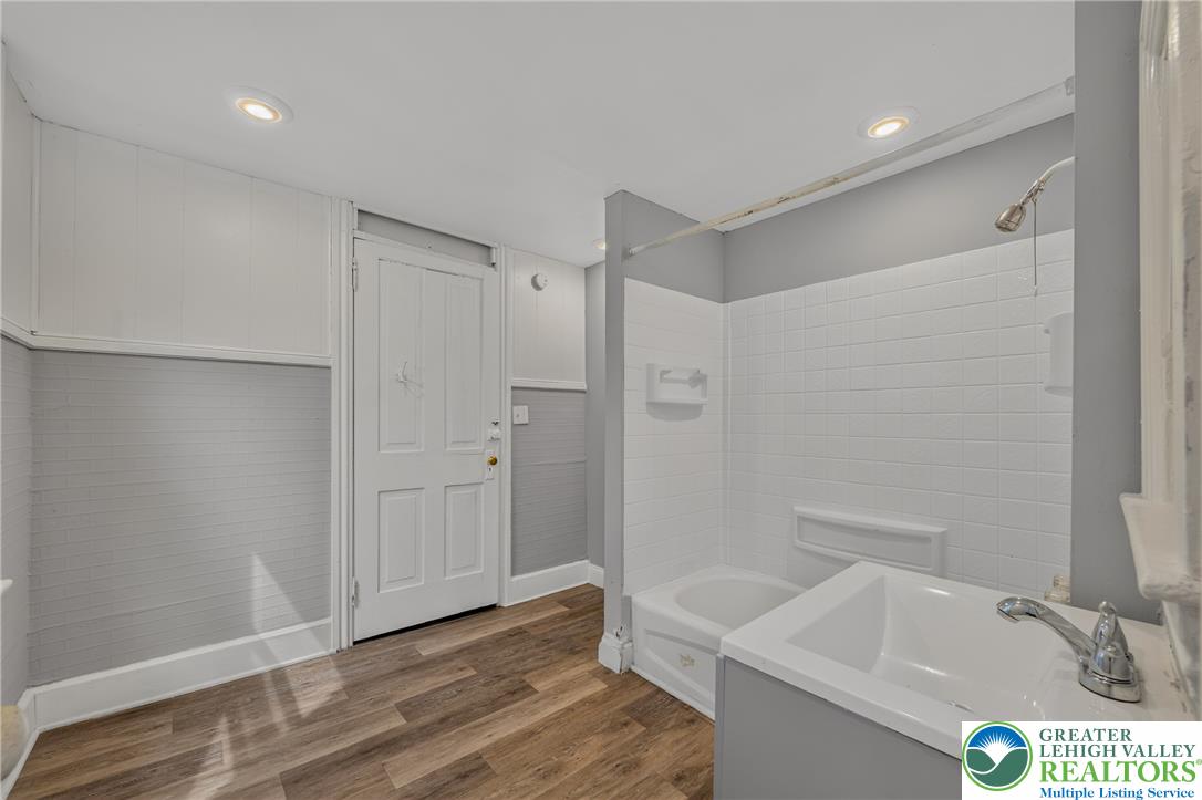 313 Main Street Slatington, PA 18080 - Photo 44 of 73 The bathroom features sleek wood-style flooring and a clean white tile shower/tub combination.