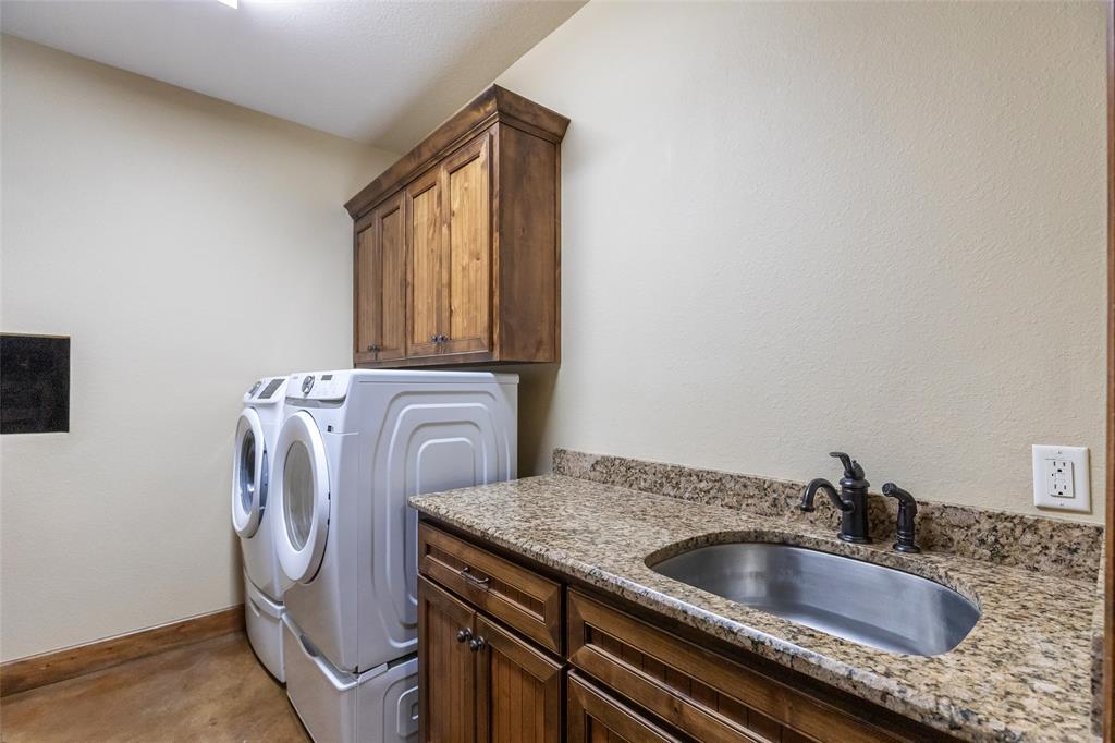 14600 Interstate 20 Roscoe, TX 79545 - Photo 20 of 40 Utility Room with Sink, Built In Cabinetry and Laundry Chute to Primary Closet