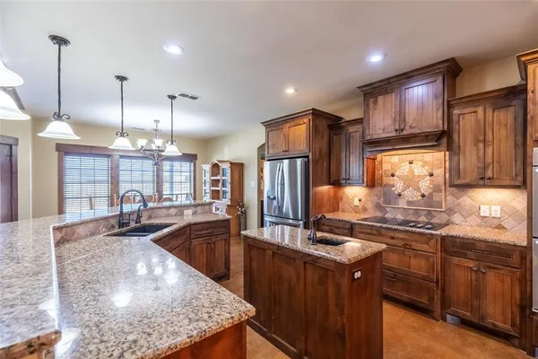 a kitchen with a stove a counter top space appliances and a living room view