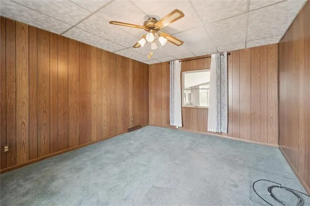 an empty room with windows and ceiling fan