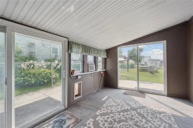 a view of a hallway with wooden floor and windows
