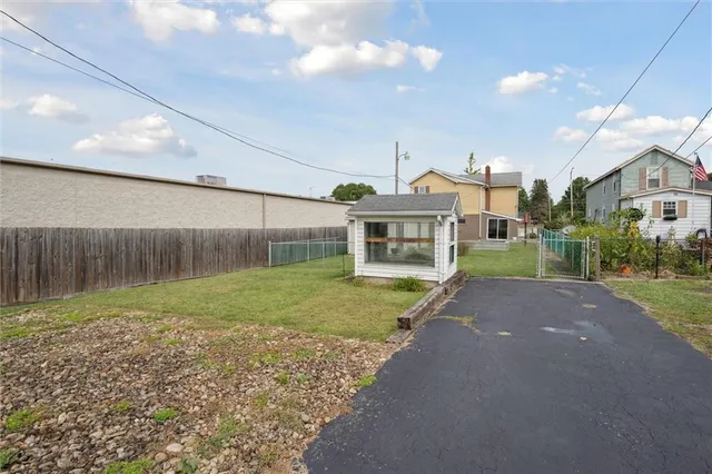 a front view of a house with garage and plants