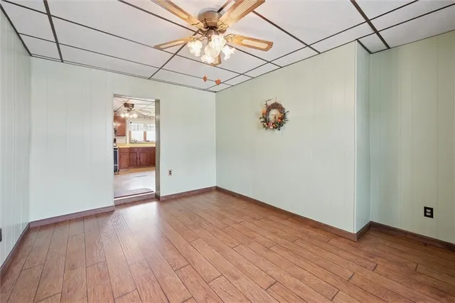 an empty room with wooden floor and chandelier