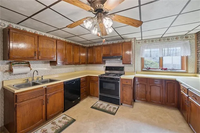 a kitchen with stainless steel appliances granite countertop a sink a stove a refrigerator with grey cabinets and granite countertops