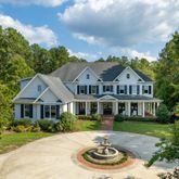 a front view of a house with yard and green space