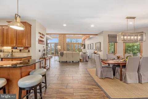 a kitchen with stainless steel appliances granite countertop a refrigerator a sink dishwasher a stove and white cabinets with wooden floor