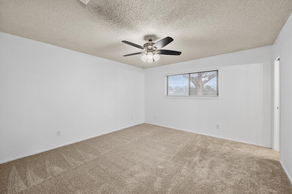 536 Robindale Lane Fairfield, TX 75840 - Photo 24 of 38 an empty room with a chandelier fan and windows