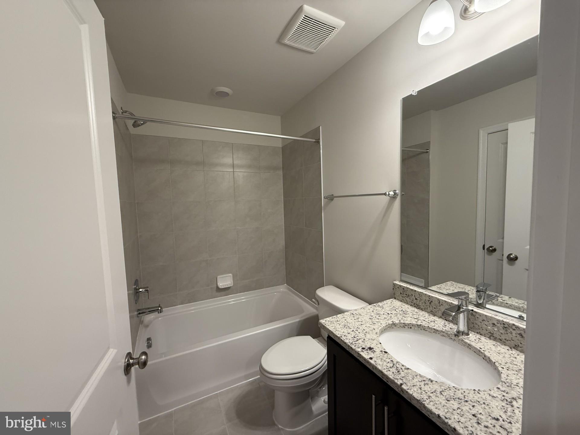 742 Compass Way Frederick, MD 21701 - Photo 22 of 30 a bathroom with a granite countertop sink toilet mirror and shower