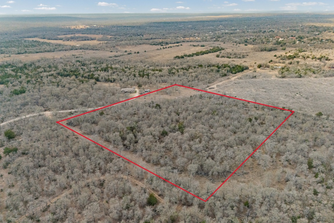 Aerial view of property and surrounding area with property parcel outlined and rural landscape