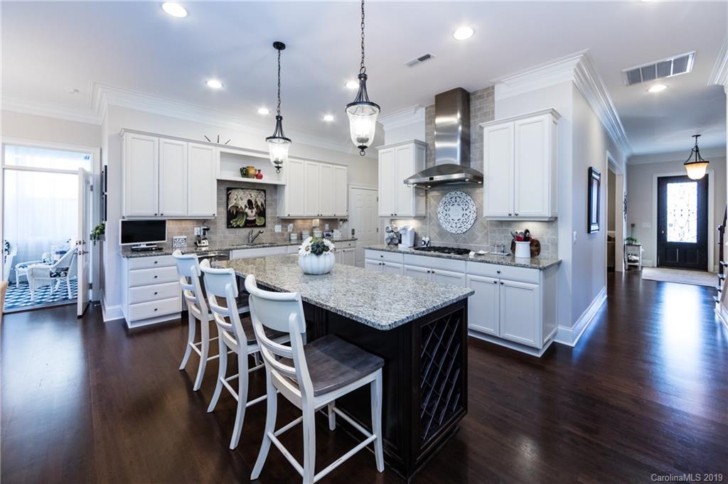 16905 Red Cow Road Charlotte, NC 28277 - Photo 11 of 47 a kitchen with stainless steel appliances kitchen island granite countertop a wooden floor and a view of living room