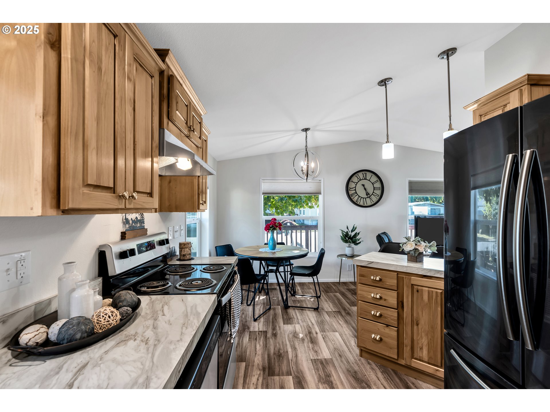 4915 Swegle Road Northeast, Unit 63 Salem, OR 97301 - Photo 12 of 36 a kitchen with a refrigerator a stove a sink and a dining table with wooden floor