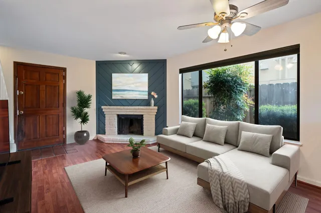 a living room with furniture fireplace and a large window