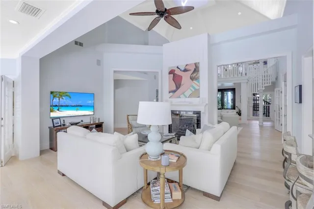 a living room with furniture a fireplace and a chandelier