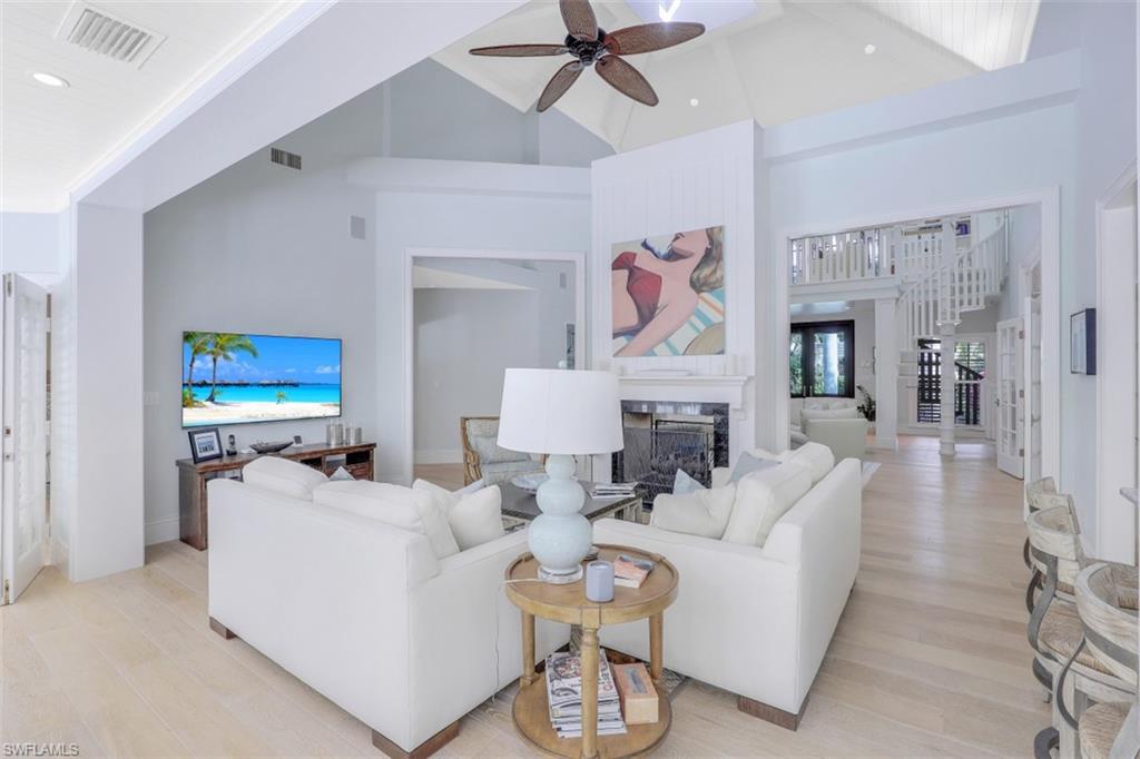 154 4th Avenue North Naples, FL 34102 - Photo 15 of 50 a living room with furniture a fireplace and a chandelier