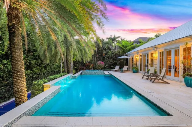 a view of a house with backyard swimming pool and sitting area