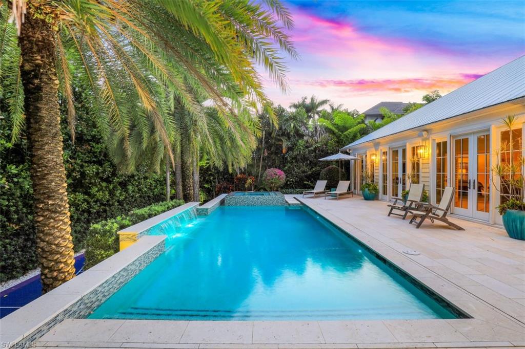 154 4th Avenue North Naples, FL 34102 - Photo 2 of 50 a view of a house with backyard swimming pool and sitting area