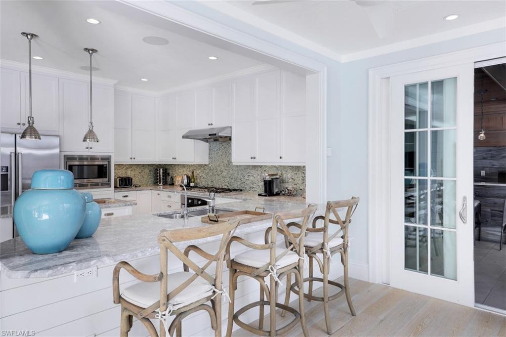 154 4th Avenue North Naples, FL 34102 - Photo 22 of 50 a dining room with furniture and a chandelier