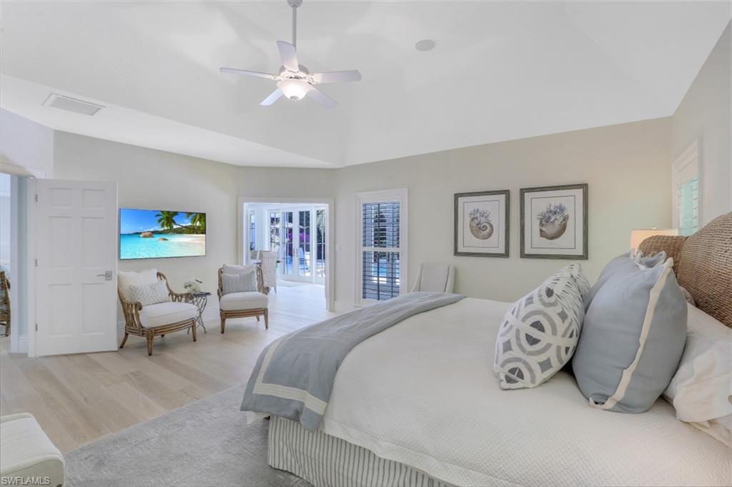 154 4th Avenue North Naples, FL 34102 - Photo 26 of 50 a bedroom with a bed and a chandelier