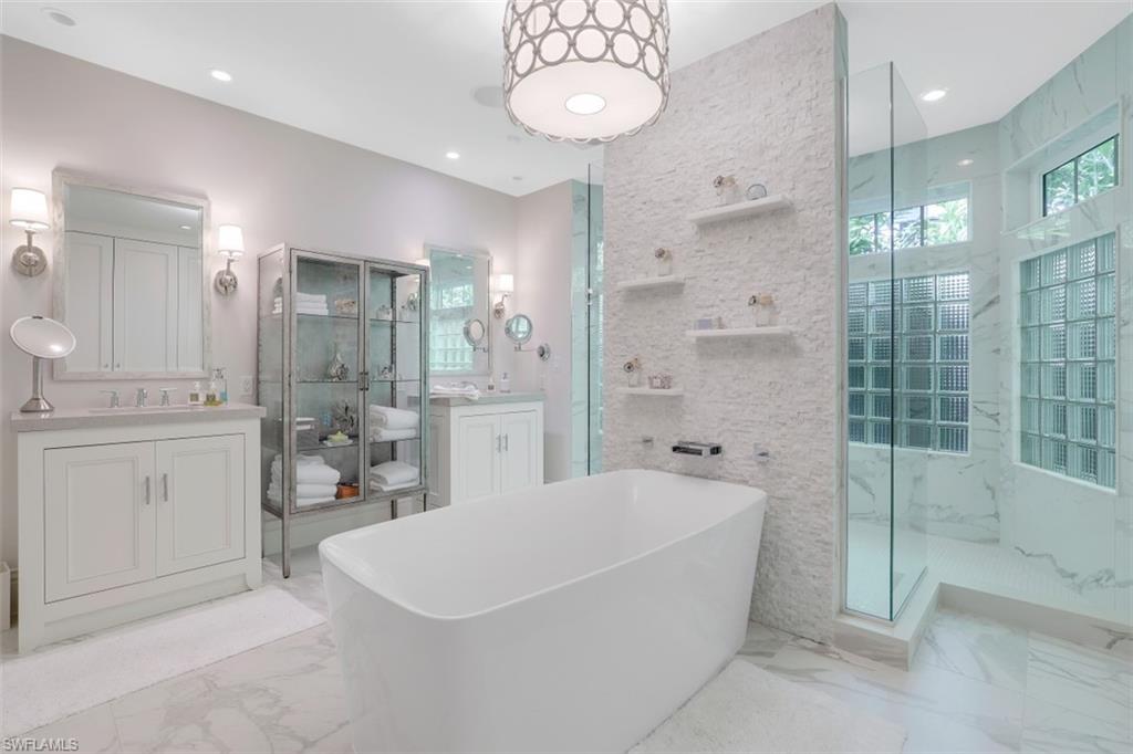 154 4th Avenue North Naples, FL 34102 - Photo 28 of 50 a spacious bathroom with a tub sink shower and mirror