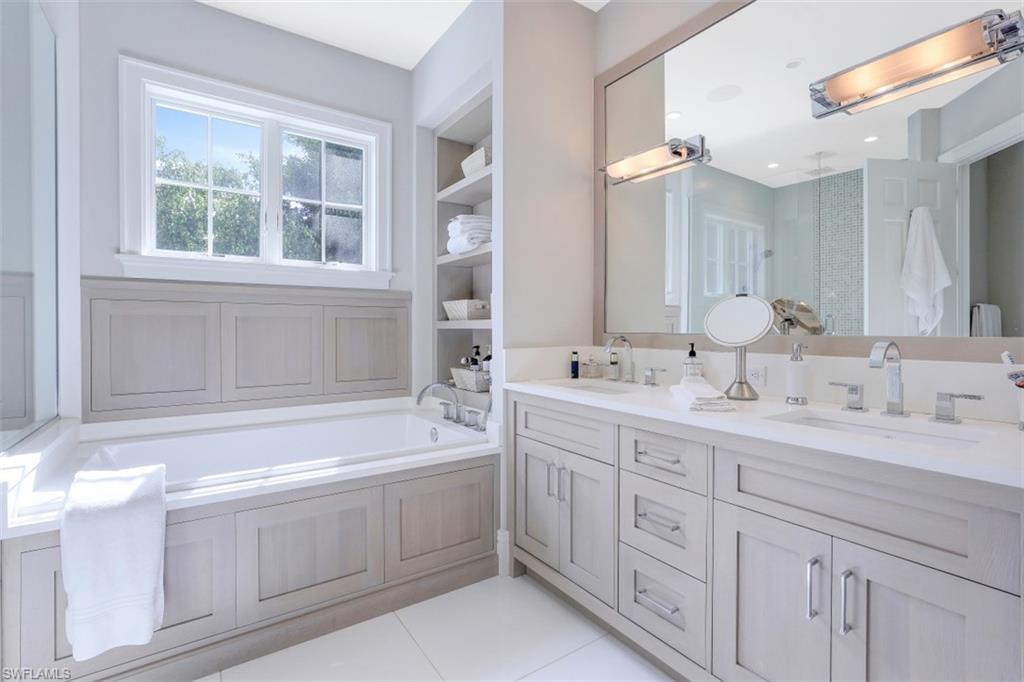 154 4th Avenue North Naples, FL 34102 - Photo 39 of 50 a bathroom with a sink double vanity and a bathtub