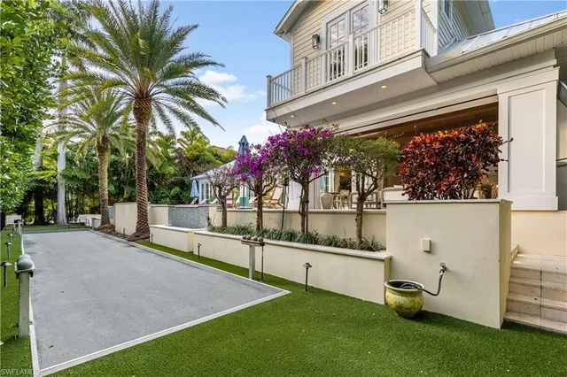 a view of a white house with a swimming pool and wooden fence