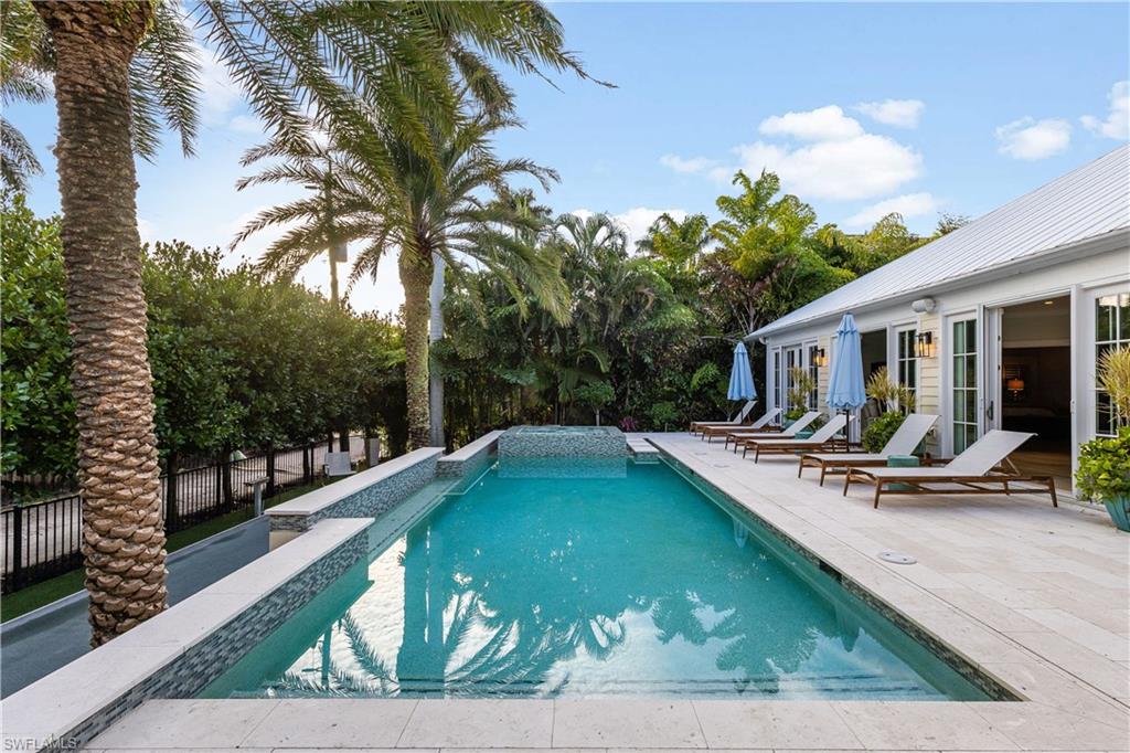 154 4th Avenue North Naples, FL 34102 - Photo 46 of 50 a view of a patio with swimming pool table and chairs