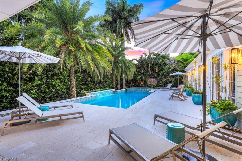 154 4th Avenue North Naples, FL 34102 - Photo 6 of 50 a view of a patio with a table and chairs under an umbrella