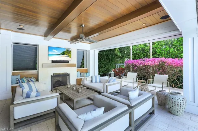 a living room with patio furniture and a fireplace