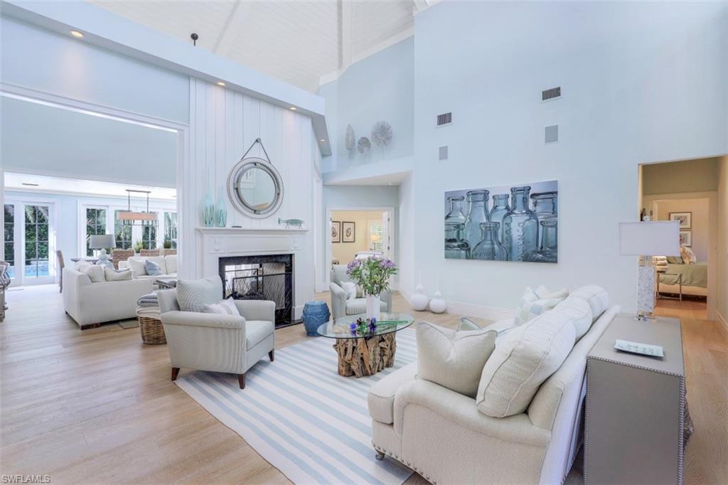 154 4th Avenue North Naples, FL 34102 - Photo 10 of 50 a living room with furniture a fireplace and a large window