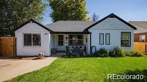 a view of a house with potted plants and a yard