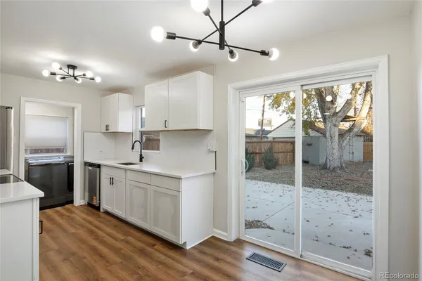 a kitchen with kitchen island white cabinets and glass door
