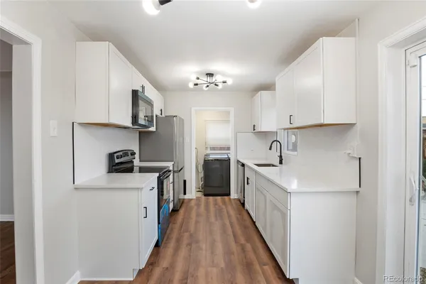 a kitchen with stainless steel appliances a sink stove and cabinets