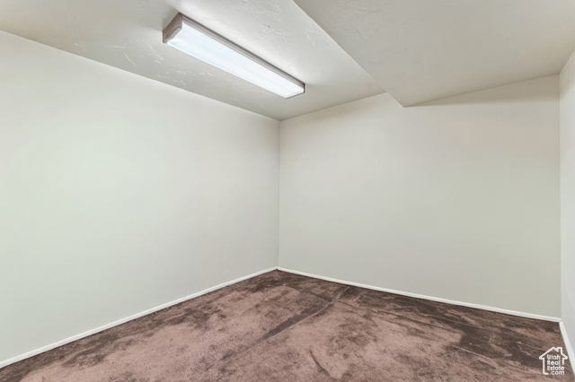 8843 Capernaum Road West Jordan, UT 84088 - Photo 20 of 31 Unfurnished room with dark carpet and vaulted ceiling