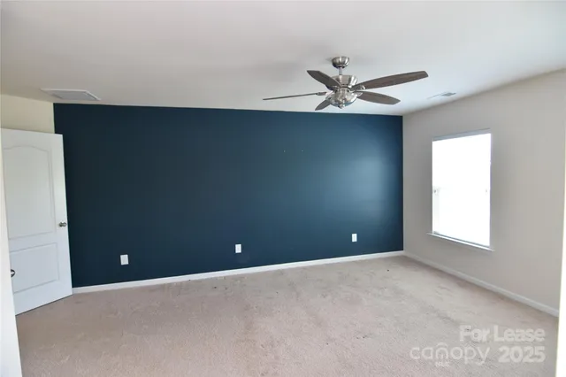 an empty room and window in ceiling fan