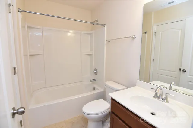 a bathroom with a bathtub shower sink vanity and toilet