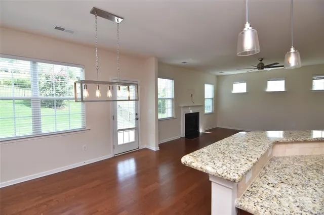 a kitchen with stainless steel appliances granite countertop a sink window and wooden floor