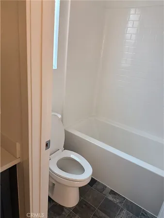 a white toilet sitting next to a bath tub