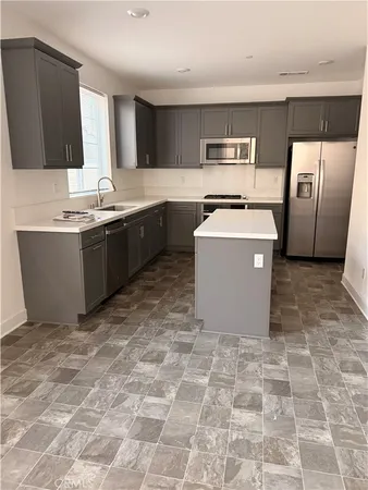 a large kitchen with a stove a sink dishwasher and a refrigerator