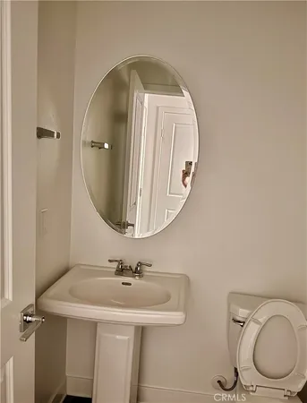 a bathroom with a toilet a sink and mirror