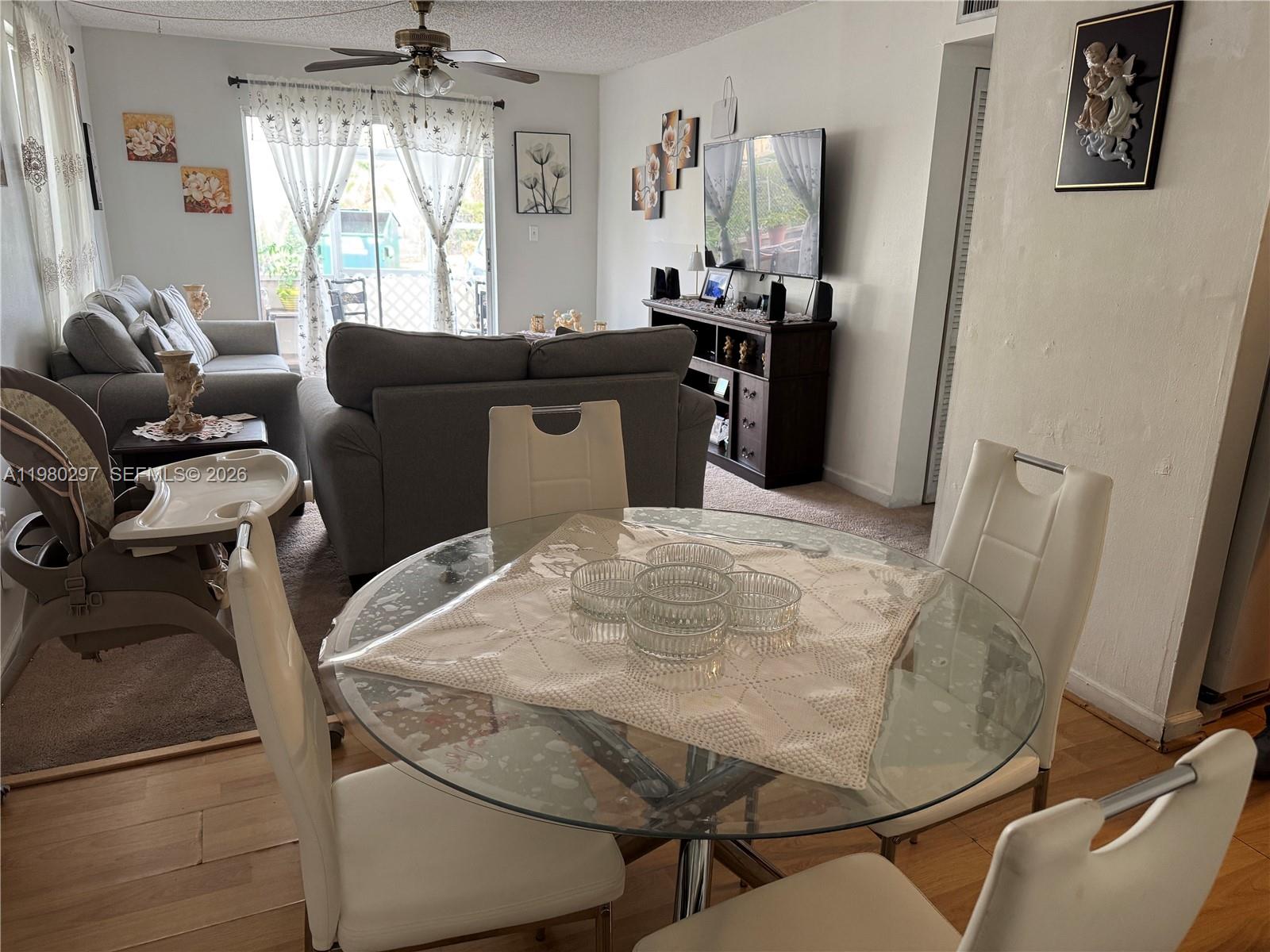 6507 Winfield Boulevard, Unit 111AC Margate, FL 33063 - Photo 12 of 42 a living room with furniture and a chandelier