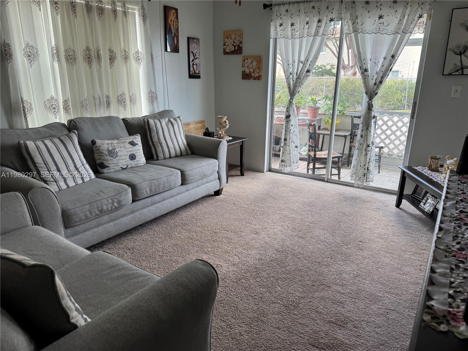 6507 Winfield Boulevard, Unit 111AC Margate, FL 33063 - Photo 13 of 42 a living room with furniture and a flat screen tv